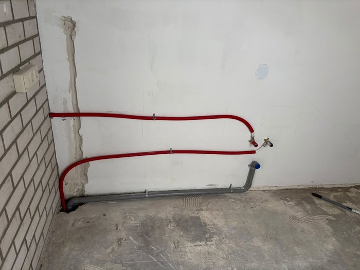 Nieuwe waterleidingen langs de muur tijdens een badkamerrenovatie