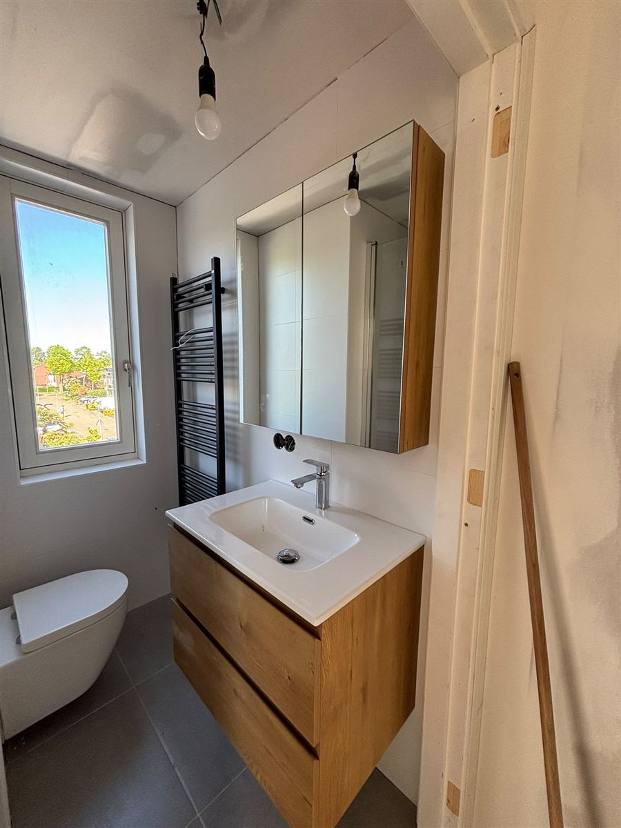 Volledig gerenoveerde badkamer met zwevend badkamermeubel, spiegelkast en zwarte designradiator