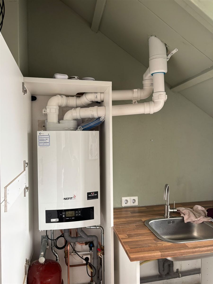 Cv-ketel netjes weggewerkt in een keukenkast, met rookgaskanaal
